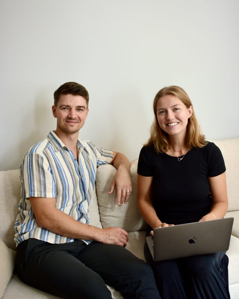 Grundarna av designstudio sitter i en soffa och tittar in i kameran